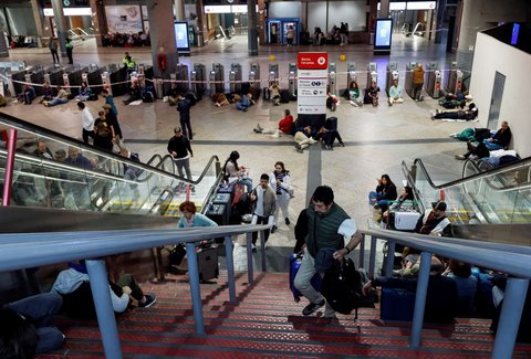Sejumlah penumpang duduk dan berbaring di lantai saat mereka bersiap untuk bermalam di Stasiun Kereta Atocha, menyusul pemadaman listrik besar-besaran di Madrid, Spanyol, pada 28 April 2025.