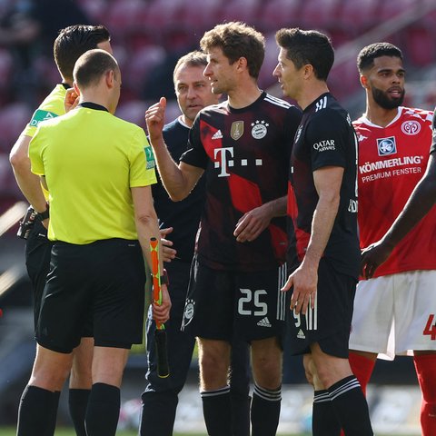 Dua striker Bayern Munich, Thomas Mueller dan Robert Lewandowski berdebat dengan wasit dan asistennya usai berakhirnya laga lanjutan Liga Jerman 2020/2021 pekan ke-31 melawan FSV Mainz di Opel Arena, Mainz, Sabtu (24/4/2021). Bayern Munich kalah 1-2 dari FSV Mainz. (AFP/Kai Pfaffenbach/Pool)
