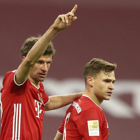 Striker Bayern Munich, Thomas Mueller (kiri) merayakan gol kedua timnya yang dicetak Joshua Kimmich (kanan) dalam laga lanjutan Liga Jerman 2020/2021 pekan ke-30 di Allianz Arena, Munich, Selasa (20/4/2021). Bayern Munich menang 2-0 atas Leverkusen. (AP/Matthias Schrader/Pool)