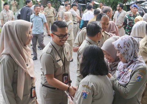 Aparatur sipil negara (ASN) saling bersalaman saat hari pertama kerja usai cuti bersama libur lebaran, Jakarta, Selasa (8/4/2025).
