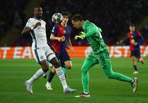 Pemain Inter Milan Marcus Thuram berhadapan dengan kiper  Barcelona's Wojciech Szczesny.