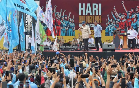 Presiden Prabowo Subianto melambaikan tangannya kepada ribuan buruh saat menghadiri peringatan Hari Buruh Internasional 2025 di kawasan Monas, Jakarta, Kamis (1/5/2025).