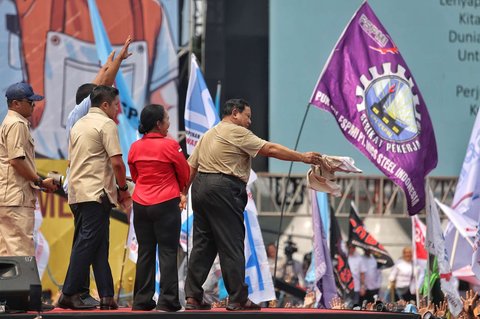 Presiden Prabowo Subianto melepas kemejanya seusai berpidato dalam peringatan May Day atau Hari Buruh Internasional 2025 di kawasan Monas, Jakarta, Kamis (1/5/2025).