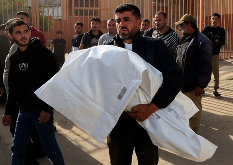 Seorang ayah menggendong jenazah anakmya yang tewas dalam serangan Israel di Rumah Sakit Nasser, di Khan Younis, di Khan Younis, Jalur Gaza Selatan, Minggu (11/05/2025).