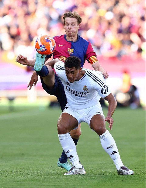 Pemain Barcelona  Frenkie de Jong berebut bola dengan pemain Real Madrid Jude Bellingham pada La Liga 2024/2025 di  Estadi Olimpic Lluis Companys, Barcelona, Spanyol, Minggu (11/05/2025).