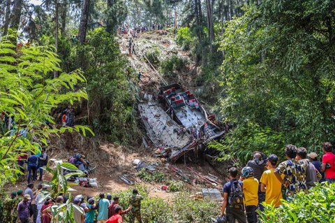 Sejumlah warga melihat upaya evakuasi bus yang terjun ke jurang di wilayah perbukitan tengah Kotmale, Sri Lanka, pada 11 Mei 2025.