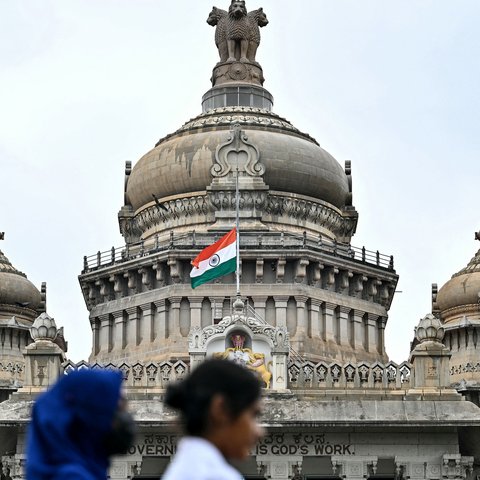 Bendera nasional India berkibar setengah tiang di Vidhana Soudha sebagai penanda berkabung atas meninggalnya mantan Perdana Menteri India, Manmohan Singh, di Bengaluru pada tanggal 27 Desember 2024. (IDREES MOHAMMED/AFP)