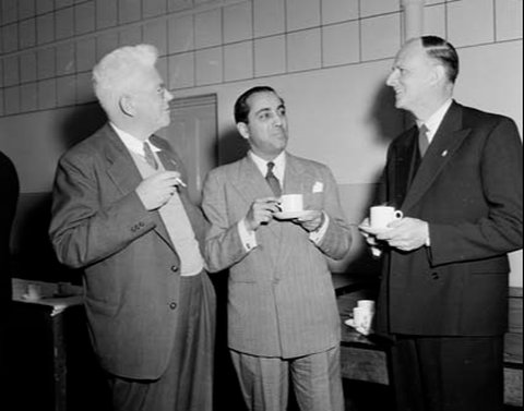 Dr. Homi Jehangir Bhabha (tengah) di acara simposium &ldquo;Kekuatan Atom di Australia&rdquo; di Sydney, Australia pada tahun 1954.