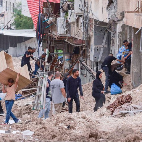 Tentara Israel mengangkat senapannya saat warga Palestina diusir dari rumah mereka saat operasi militer Israel di kamp pengungsi Tulkarem di barat laut Tepi Barat,  Palestina (02/05/2025)