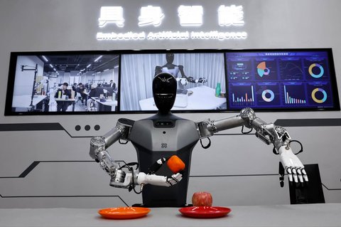 Robot humanoid Tiangong Beijing Innovation Center of Humanoid Robotics Co memindahkan jeruk  di Pusat Inovasi Beijing milik Humanoid Robotics Co di kawasan Industri Robotika di Beijing, China (16/05/2025).