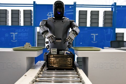 Robot humanoid Walker S milik Ubtech mengambil benda-benda di Pusat Inovasi Beijing milik Humanoid Robotics Co di kawasan Industri Robotika di Beijing, China (16/05/2025).