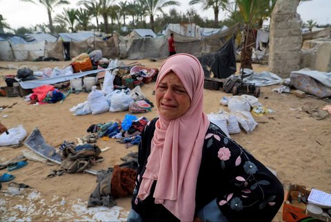Seorang ibu menangis  di lokasi serangan Israel terhadap kamp tenda yang menampung pengungsi, di Khan Younis, Jalur Gaza selatan, Minggu (18/05/2025).