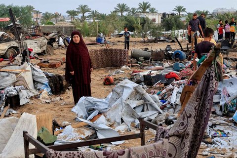 Warga Gaza memeriksa kerusakan di lokasi serangan Israel terhadap kamp tenda yang menampung pengungsi, di Khan Younis, Jalur Gaza selatan, Minggu (18/05/2025).