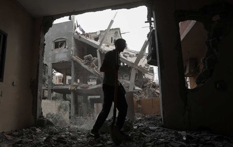 Warga Gaza memeriksa kerusakan akibat serangan Israel di Jalur Gaza bagian tengah,  Minggu (18/05/2025).