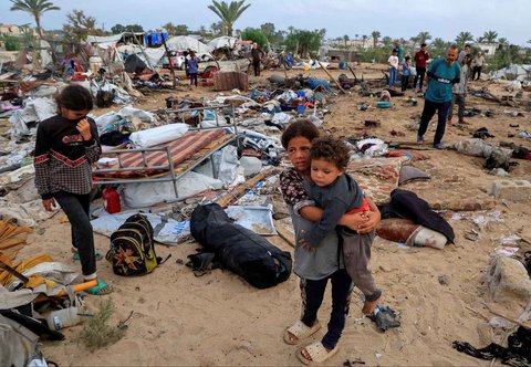Warga Gaza memeriksa kerusakan di lokasi serangan Israel terhadap kamp tenda yang menampung pengungsi, di Khan Younis, Jalur Gaza selatan, Minggu (18/05/2025).