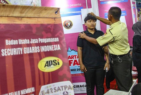 Pencari kerja melakukan tes tinggi badan pada Bursa Kerja Jakarta di GOR Ciracas, Jakarta, Senin (19/5/2025)