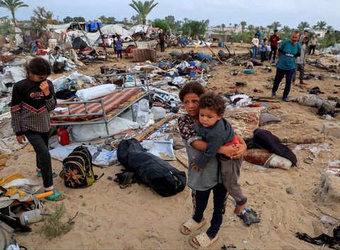 Warga Gaza memeriksa kerusakan di lokasi serangan Israel terhadap kamp tenda yang menampung pengungsi, di Khan Younis, Jalur Gaza selatan, Palestina, Minggu (18/05/2025)