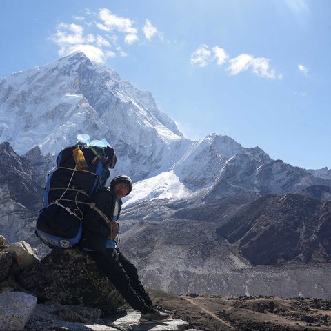Pendaki berjalan menuju base camp Everest  dengan latar belakang Gunung Everest dari Lobuche di distrik Solukhumbu, Nepal (12/04/2025)