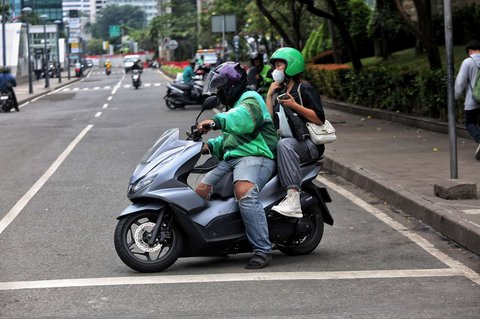 Seorang pengemudi ojol tengah menjemput penumpang di kawasan Dukuh Atas, Jakarta, pada Selasa (20/5/2025). Di tengah demo besar-besaran dan aksi mogok massal menuntut regulasi tarif yang lebih adil, sejumlah pengemudi ojol tetap beroperasi.