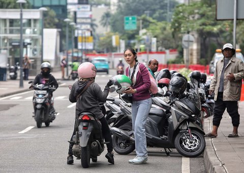 Seorang pengemudi ojol tengah menjemput penumpang di kawasan Dukuh Atas, Jakarta, pada Selasa (20/5/2025). Di tengah demo besar-besaran dan aksi mogok massal menuntut regulasi tarif yang lebih adil, sejumlah pengemudi ojol tetap beroperasi.