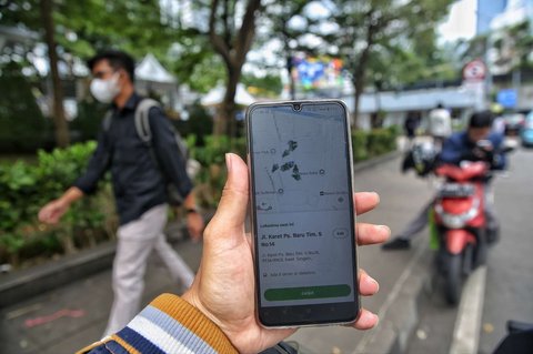 Seorang pengemudi ojol tengah menjemput penumpang di kawasan Dukuh Atas, Jakarta, pada Selasa (20/5/2025). Di tengah demo besar-besaran dan aksi mogok massal menuntut regulasi tarif yang lebih adil, sejumlah pengemudi ojol tetap beroperasi.