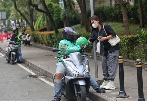 Seorang pengemudi ojol tengah menjemput penumpang di kawasan Dukuh Atas, Jakarta, pada Selasa (20/5/2025). Di tengah demo besar-besaran dan aksi mogok massal menuntut regulasi tarif yang lebih adil, sejumlah pengemudi ojol tetap beroperasi.