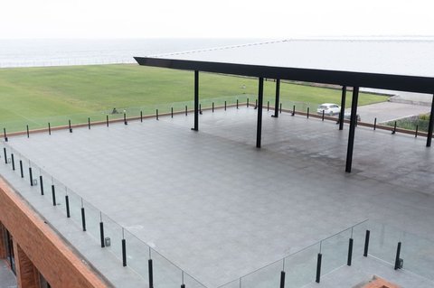 Suasana rooftop area yang bisa dimanfaatkan untuk acara atau kegiatan luar ruangan, dengan pemandangan 4 lapangan latihan dan Pantai Purnama yang indah.