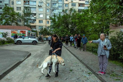 Warga menyelamatkan anjingnya usai serangan pesawat drone militer Rusia di Kyiv, Ukraina, Sabtu (24/05/2025).