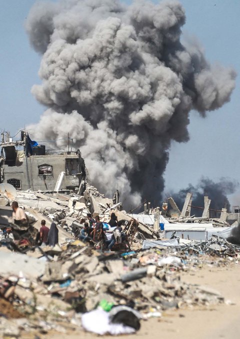Warga  menyaksikan asap mengepul menyusul serangan udara Israel di Jabalia, di Jalur Gaza utara, Minggu (25/05/2025).