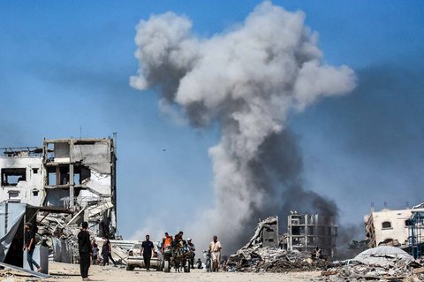 Warga  menyaksikan asap mengepul menyusul serangan udara Israel di Jabalia, di Jalur Gaza utara, Minggu (25/05/2025).