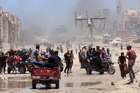 Warga Palestina mengangkut barang-barang mereka saat mereka melarikan diri dari Jalur Gaza utara ke selatan, di sepanjang jalan pesisir al-Rashid, Minggu (25/05/2025).
