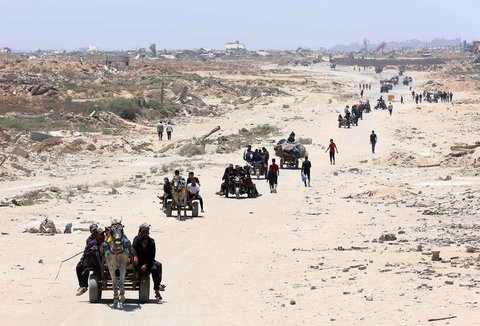 Warga Palestina mengangkut barang-barang mereka saat mereka melarikan diri dari Jalur Gaza utara ke selatan, di sepanjang jalan pesisir al-Rashid, Minggu (25/05/2025).