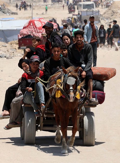 Warga Palestina mengangkut barang-barang mereka saat mereka melarikan diri dari Jalur Gaza utara ke selatan, di sepanjang jalan pesisir al-Rashid, Minggu (25/05/2025).
