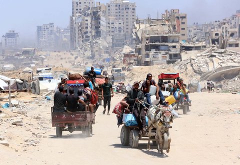 Warga Palestina mengangkut barang-barang mereka saat mereka melarikan diri dari Jalur Gaza utara ke selatan, di sepanjang jalan pesisir al-Rashid, Minggu (25/05/2025).