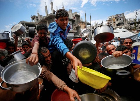 Warga Palestina antri mengambil  makanan yang dimasak di  Dapur Amal, di Beit Lahiya, Jalur Gaza utara, Senin (28/04/2025).