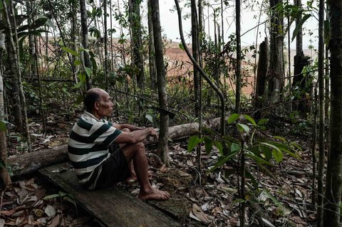 Tetua suku Adat Hongana Manyawa, Ngigoro (62 tahun) yang terpaksa meninggalkan hutan dan kini tinggal di desa bersama ibunya, duduk mengamati lokasi penambangan nikel di Halmahera Timur, Maluku Utara (16/04/2025).