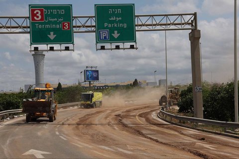 Anggota dinas keamanan Israel memeriksa kawah yang muncul dari rudal yang dikirimkan dari Yaman di luar bandara Ben Gurion Israel, Minggu (04/05/2025).