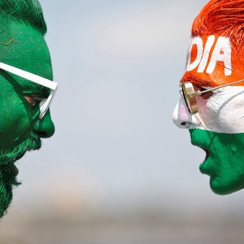 Penggemar kriket mengecat wajah dengan warna bendera nasional India dan Pakistan saat pertandingan pertama antara India dan Pakistan pada 23 Oktober 2021.