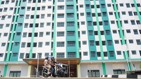 Seorang pengendara motor melintas di depan Rusunawa Jagakarsa, Jakarta, Jumat (9/5/2025). Pemerintah Provinsi DKI Jakarta resmi membuka hunian vertikal ini sebagai bagian dari upaya penyediaan tempat tinggal layak dan terjangkau bagi warga ibu kota.