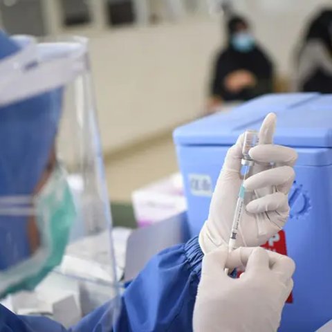 Seorang petugas kesehatan menyiapkan suntikan vaksinasi COVID-19.