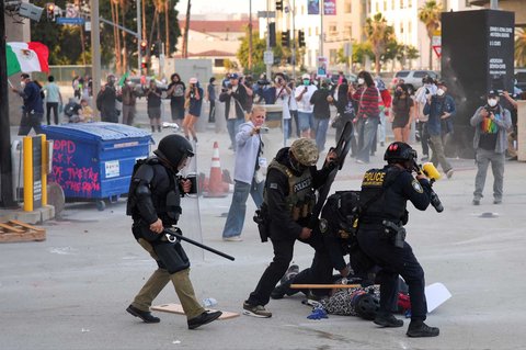 Seorang pengunjuk rasa melemparkan batu saat unjuk rasa para imigran, di kota Paramount, California, AS, (07/06/2025).
