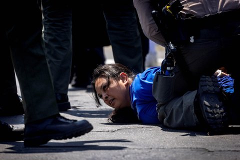 Seorang pengunjuk rasa melemparkan batu saat unjuk rasa para imigran, di kota Paramount, California, AS, (07/06/2025).