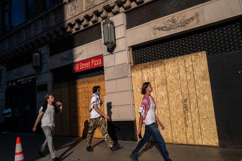 Warga berjalan melewati toko yang tutup kayu  di Los Angeles, Amerika Serikat, (10/06/2025)