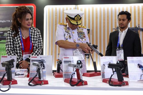Seorang personel TNI AL memegang pistol pada pameran Indo Defense 2024 Expo and Forum di  Jakarta, Selasa (11/06/2025).
