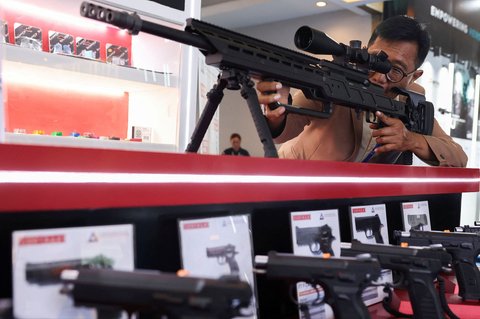 Seorang pengunjung memegang TTR Sniper.308 pada pameran Indo Defense 2024 Expo and Forum di  Jakarta, Selasa (11/06/2025).