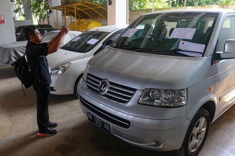 Jurnalis memantau langsung proses lelang barang hasil rampasan dari perkara korupsi di Rumah Penyimpanan Benda Sitaan dan Barang Rampasan Negara (Rupbasan), Cawang, Jakarta Timur, Kamis (12/6/2025).