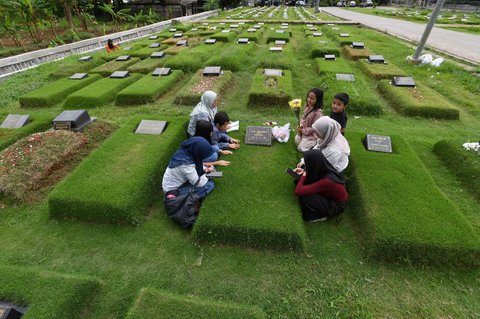 Warga berziarah di pemakaman khusus korban Covid-19 di TPU Srengseng Sawah, Jakarta, pada hari kedua perayaan Idulfitri 1446 Hijriah, Selasa (1/4/2025).