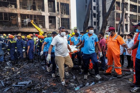 Petugas penyelamat membawa jenazah korban di lokasi jatuhnya pesawat Air India AI171 di kawasan permukiman di dekat Bandara Internasional Sardar Vallabhbhai Patel, Ahmedabad, Gujarat, India, pada 12 Juni 2025.