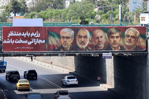 Poster yang menampilkan potret jenderal militer dan ilmuwan nuklir Iran yang tewas dalam serangan Israel terpasang di sudut kota di Teheran,  Sabtu (14/06/2025).