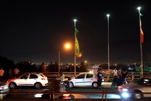 Warga keluar ke jalan saat kebakaran depot minyak Sharhan akibat serangan udara di Teheran, Iran Minnggu (15/06/2025).